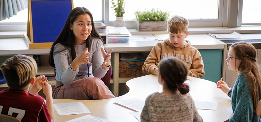 Student teacher in the classroom surrounded by young children